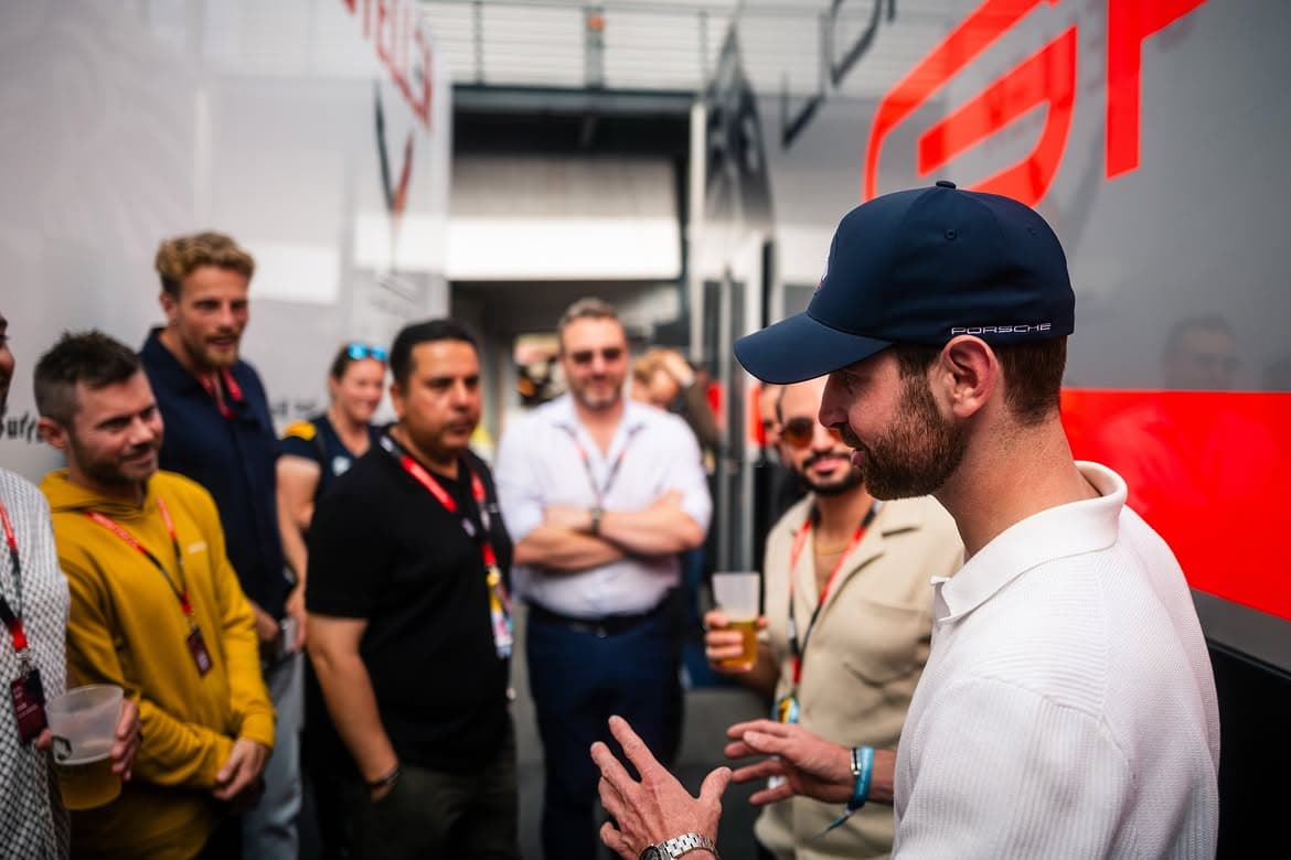 A guest talking with a team member in the garage during a GT3 race weekend